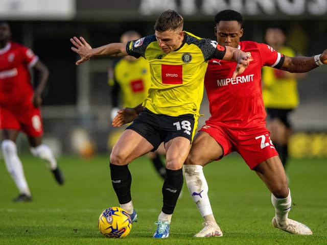 Jack Muldoon  holds off Udoka Godwin-Malife.Harrogate Town v Swindon Town.  SkyBet League 2. Envirovent Stadium.Picture Bruce Rollinson18 November 2023.