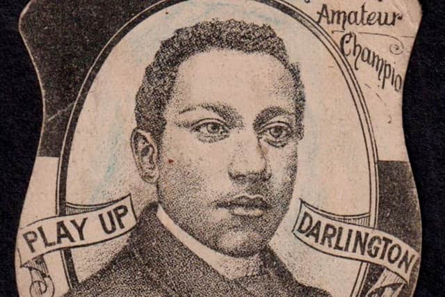 A football card of the world's first black professional player has sold for over £26,000 at auction