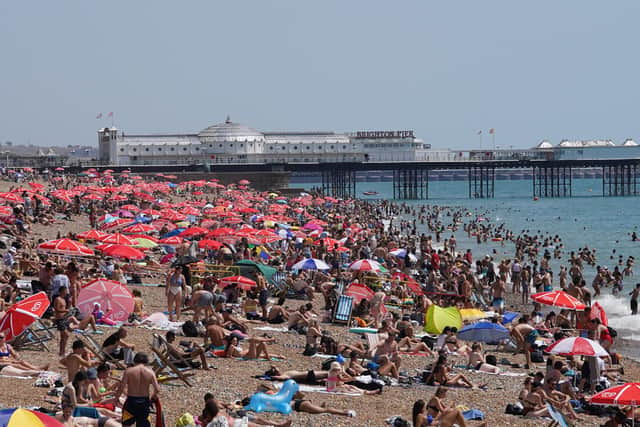 People basking in the sun on a crowded Brighton beach last summer. Both going abroad and staying in the UK for holidays has become considerably more expensive, Sarah Coles says.