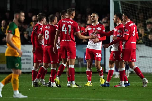 GOING THROUGH: Barnsley's John McAtee (hidden) celebrates scoring their side's third goal of the game with team-mates Picture: Adam Davy/PA