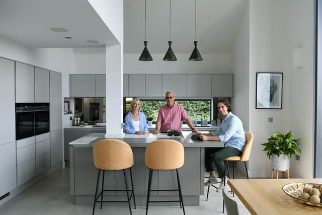 Will Slack with his parents in the kitchen area of the open plan living space. The cabinetry is by Leicht