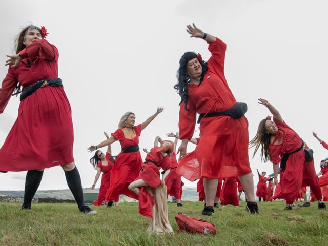 Participants gather at Penistone Country Park in Haworth for Actually the Most Wuthering Heights Day Ever - a celebration of all things Wuthering Heights, Kate Bush and Emily Brontë in the stunning setting of the Haworth moors.  500 people took part in the mass 'Wuther' in a joyful, windswept, red-dress sea of Cathys dancing for charity, supporting  Women’s Aid Picture by Tony Johnson.  24th July 2026