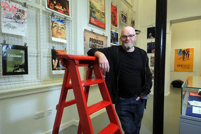 Artistic director Rod Dixon at the launch of exhibition marking the 50th anniversary of Leeds's Red Ladder Theatre Company pictured by the 'poster wall' and the original red ladder that inspired the company's name at Leeds Central Library.   Picture Tony Johnson.