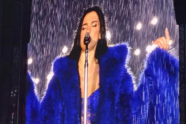 Dua Lipa sings through a downpour at Anfield.