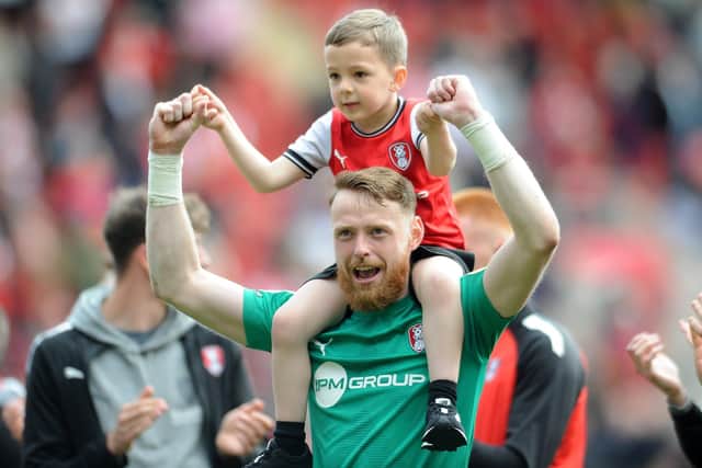 PRIZE ASSET: Rotherham United goalkeeper Viktor Johansson celebrates staying up with his son