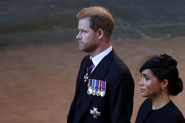 Prince Harry and Meghan, Duchess of Sussex walk as procession with the coffin of Britain's Queen Elizabeth arrives at Westminster Hall from Buckingham Palace for her lying in state. (Pic credit: Phil Noble - WPA Pool / Getty Images)