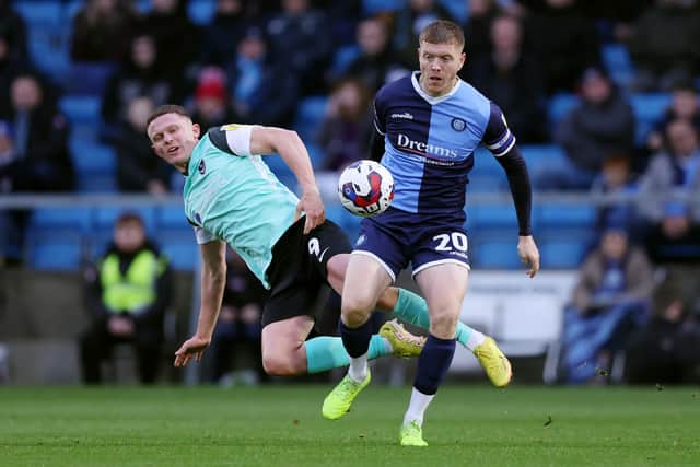 HIGH WYCOMBE, ENGLAND - DECEMBER 04: Alfie Mawson of Wycombe Wanderers is challenged by Colby Bishop of Portsmouth during the Sky Bet League One between Wycombe Wanderers and Portsmouth at Adams Park on December 04, 2022 in High Wycombe, England. (Photo by Alex Morton/Getty Images)