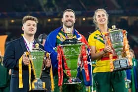 World Cup winning captains Tom Halliwell (England wheelchair), James Tedesco (Australia men) and Kezie Apps (Australia women) with their trophies on the pitch at Old Trafford. (Picture by Allan McKenzie/SWpix.com)