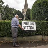 A man adjusts a polling station sign at Saint Martin Church in Womersley. PIC: Danny Lawson/PA Wire