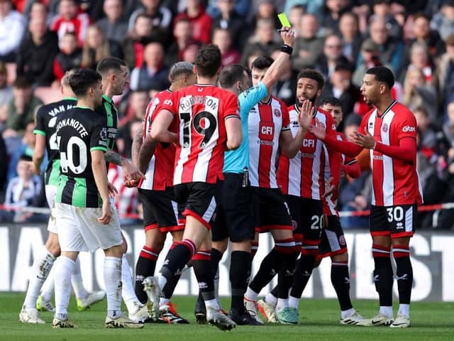 FOUL PLAY: Referee Stuart Attwell shows a yellow card to Mason Holgate of Sheffield United, which is later upgraded to a red