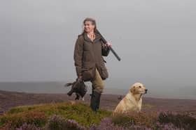 A woman carries grouse and a gun as she walks with her dog at a shooting party on the moors in North Yorkshire as the Glorious 12th, the official start of the grouse shooting season, gets underway. Photo credit: Danny Lawson/PA Wire