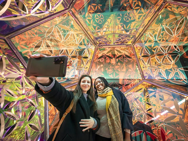 Left to right Eva Karagiannakou and Fatima Riake take a photograph with light installation Seed of Life by artist Amberlights, part of Light Night Leeds, the UK's largest annual arts and light festival. Photo credit: Danny Lawson/PA Wire