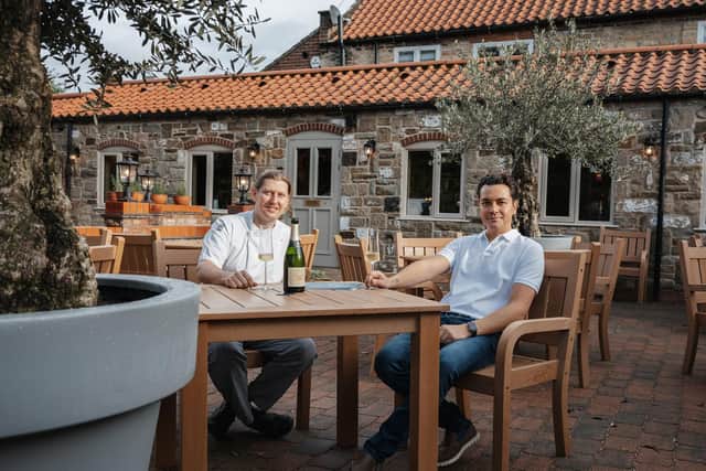 Owners Gianpaul Redolfi, left, and Alex Stothard enjoy a glass of champagne on the outdoor terrace at their new restaurant, Villa d’Este, in Ellerker, near Brough, East Yorkshire. Picture: Josh Dowler