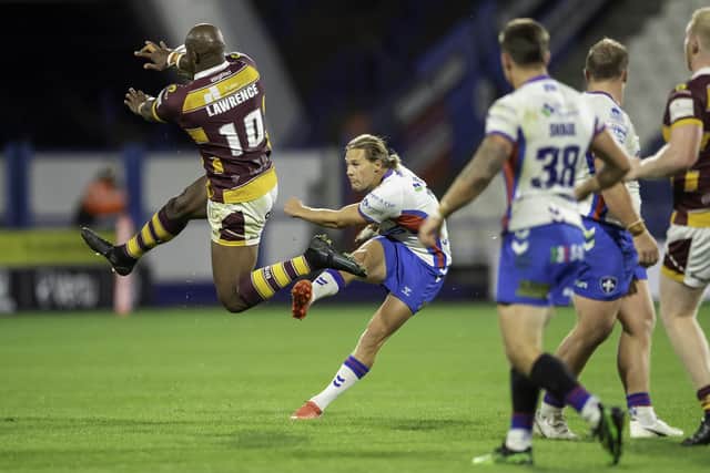 Wakefield's Jacob Miller attempts a drop goal which is blocked by Huddersfield's Michael Lawrence. (Photo: Allan McKenzie/SWpix.com)