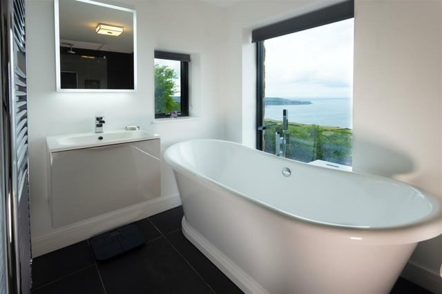 The ground floor bathroom has a beautiful double ended roll top bath next to a large feature window enjoying views out to sea, a generous walk-in shower plus a WC and wash basin with storage.