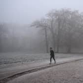 A runner makes their way through fog on a frosty morning. (Pic credit: Justin Tallis / AFP via Getty Images)