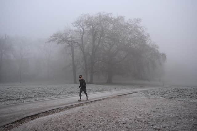 A runner makes their way through fog on a frosty morning. (Pic credit: Justin Tallis / AFP via Getty Images)