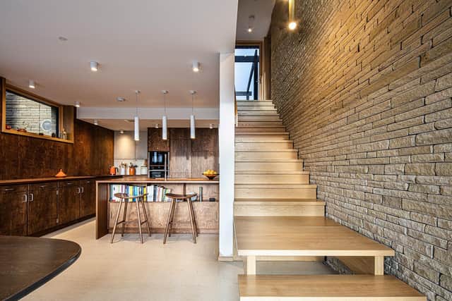 The stairs and exposed wall in all their glory lead down to the bespoke kitchen with stained ply cabinets