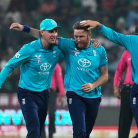 England's Liam Dawson celebrates with teammates after taking the wicket of Pakistan's Salman Ali Agha in Lahore on Sunday. Picture: AP/K.M. Chaudary.