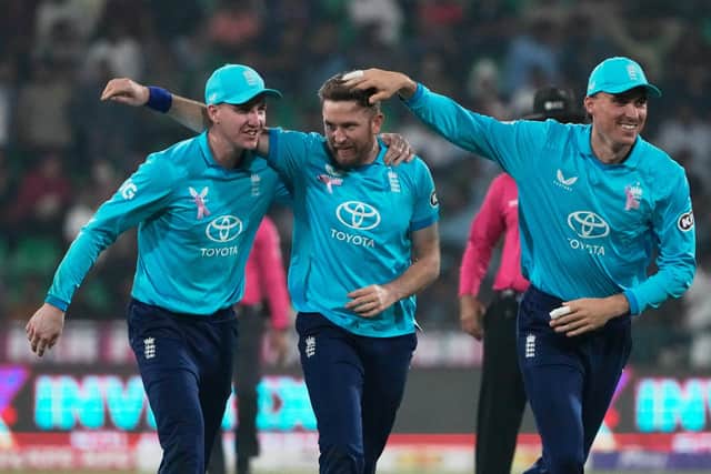 England's Liam Dawson celebrates with teammates after taking the wicket of Pakistan's Salman Ali Agha in Lahore on Sunday. Picture: AP/K.M. Chaudary.