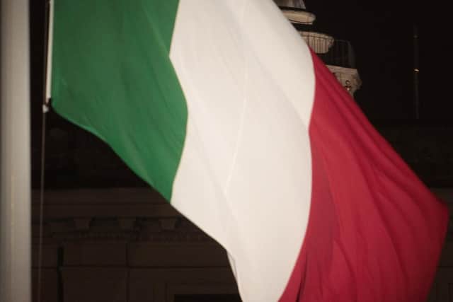 The Italian flag raised in front of a statue of the Virgin Mary in Rome. PIC: AP Photo/Gregorio Borgia