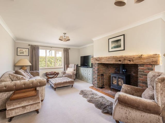 Measuring more than 24ft, the sitting room features a wood-burning stove and views towards the front garden.