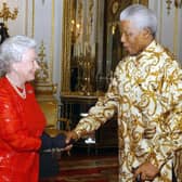 Britain's Queen Elizabeth II (L) meets with former South African President Nelson Mandela (R) during a reception at Buckingham Palace in London on October 20, 2003. Former Yorkshire MP Richard Caborn has said he was a "little bit economical with the truth" in telling Mr Mandela that the Queen wanted him to support the London Olympic bid. Photo by KIRSTY WIGGLESWORTH / POOL / AFP)