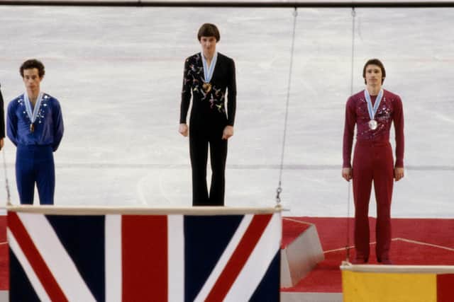 Robin Cousins of Great Britain watches the raising of the Union Jack flag with second placed silver medallist Jan Hoffman (r) and bronze medallist Charles Tickner after winning the gold medal in the mens singles figure skating competition at the XII Olympic Winter Games on 21st February 1980 at the Olympic Center Arena in Lake Placid, New York, United States. (Picture: Getty Images)