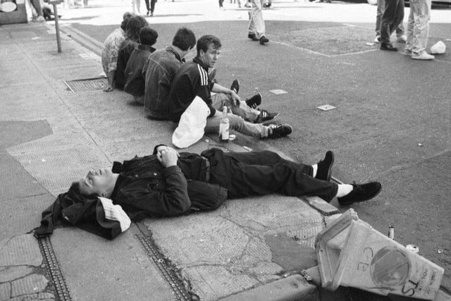 A music fan takes a nap on the pavement after the Glasgow's Big Day concert in June 1990.