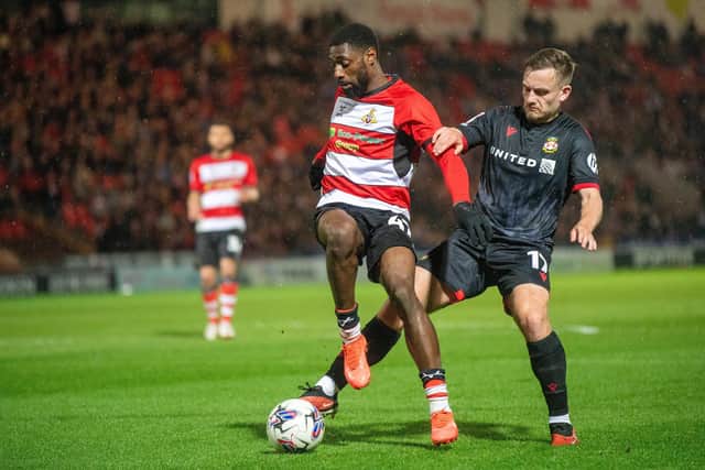 HOLDING ROLE: Doncaster Rovers forward Hakeeb Adelakun keeps Luke Bolton at bay