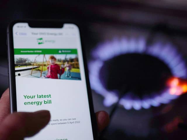 A general view of a household energy bill displayed on a mobile phone held next to a gas hob. PIC: Yui Mok/PA Wire