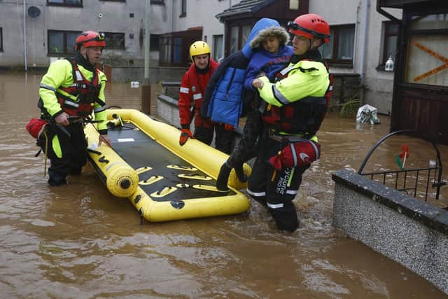 BRECHIN,SCOTLAND - OCTOBER 20: Members of the coastguard rescue a family from flood waters surrounding the houses on October 20, 2023 in Brechin Scotland. Areas close to the river have been overwhelmed by water which breached the flood defences in the early hours of this morning. Rare Red weather warnings are in place in Scotland and amber warnings in the north of England until Saturday as Storm Babet sweeps the country. (Photo by Jeff J Mitchell/Getty Images)