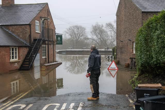 A member of the public looks at the flooding by The Ship Inn at Acaster Malbis near York where the River Ouse breached its banks