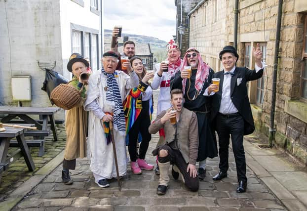The cast of the Heptonstall Pace Egg having a Good Friday pint in the village between performances in Weavers Square in the West Yorkshire Village.