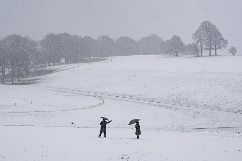 A couple walk in heavy snow in Roundhay Park, Leeds.