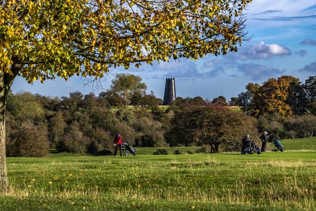 Golfers play on Beverley's Westwood Pasture with Black Mill in the background in glorious autumnal sunshine
