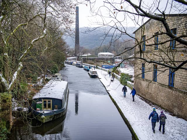 Walkers on the towpath beside the Rochdale Canal in Hebden Bridge as snow hit the region. PIC: Tony Johnson.