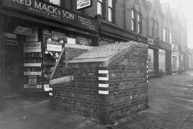 Fred Mack & Son, Newsagent & Stationers on Brudenell Road in October 1941. The premises also housed the Brudenell Lending Library. Brick structure with blackout markings and broken glass to roof  (possibly an air raid shelter ) can be seen on pavement.