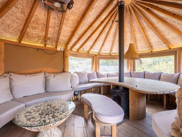 This thatched garden room is a sociable space for alfresco dining and gatherings.