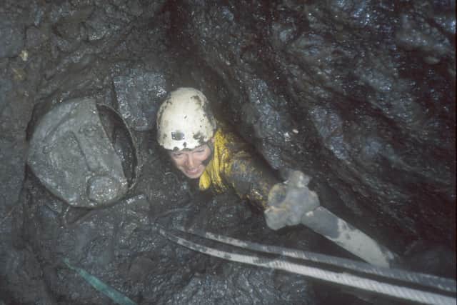 A caver excavates the entrance to Newby Moss Cave. Photo: David Williams