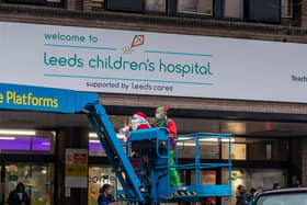 A Father Christmas on a cherry picker outside Leeds Children's Hospital waves at children through windows in 2020. PIC:  James Hardisty.
