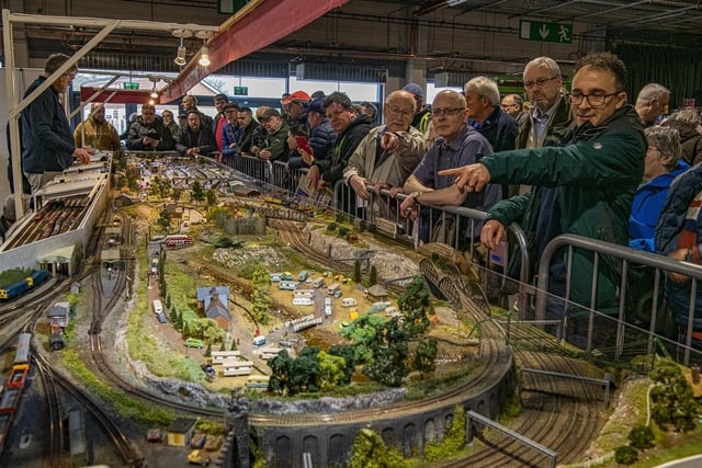 Enthusiasts admire the layouts.