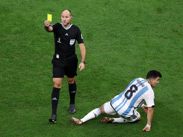 LUSAIL CITY, QATAR - DECEMBER 09: Referee Antonio Mateu shows a yellow card to Jurrien Timber of Netherlands after his challenge on Marcos Acuna of Argentina during the FIFA World Cup Qatar 2022 quarter final match between Netherlands and Argentina at Lusail Stadium on December 09, 2022 in Lusail City, Qatar. (Photo by Elsa/Getty Images)