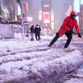 A worker with the Times Square Alliance sanitation crew shovels snow in Times Square, New York. PIC: AP Photo/Seth Wenig