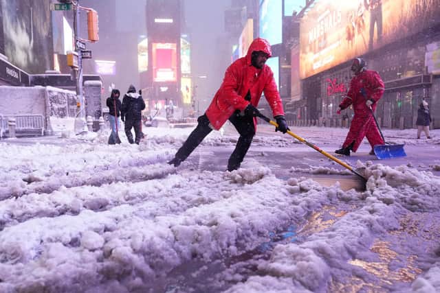 A worker with the Times Square Alliance sanitation crew shovels snow in Times Square, New York. PIC: AP Photo/Seth Wenig
