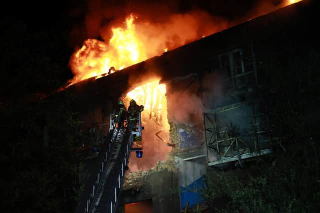 Rescue workers try to put out a fire of a residential building burning after a Russian drone attack on Zaporizhzhia, Ukraine. PIC: AP Photo/Kateryna Klochko