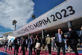 People walk past the MIPIM international real estate event for professionals at the Palais des Festivals in Cannes, southeastern France, on March 14, 2023. (Photo by Valery HACHE / AFP) (Photo by VALERY HACHE/AFP via Getty Images)