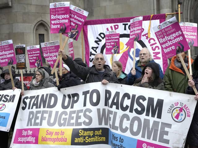 Stand Up To Racism campaigners hold banners outside the High Court in London. (AP Photo/Kirsty Wigglesworth)