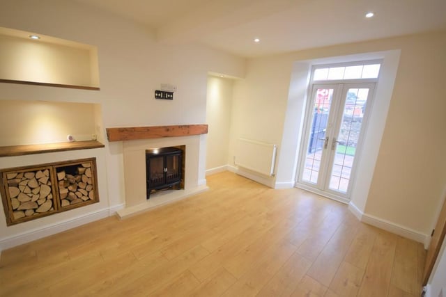 Lounge -  A quaint and comfortable snug having a free standing electric fire sat with a marble surround and French doors open to the courtyard, laminate flooring, sockets, tv point and downlights.