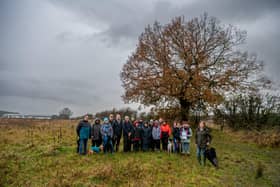 A group of residents from North Ferriby near Hull have been campaigning against the felling of a veteran oak on the Amazon site at Melton Fields, Melton West Business Park, North Ferriby, Hull. The Oak tree T3 which is growing in the middle of the site will be felled and nearby T4 which is on the edge of the site has a 'watching brief' and faces an uncertain future. Pictured Campaigners near Oak tree, (T4) with (T3) visible in the background.
Picture By Yorkshire Post Photographer,  James Hardisty. Date: 4th December 2023.